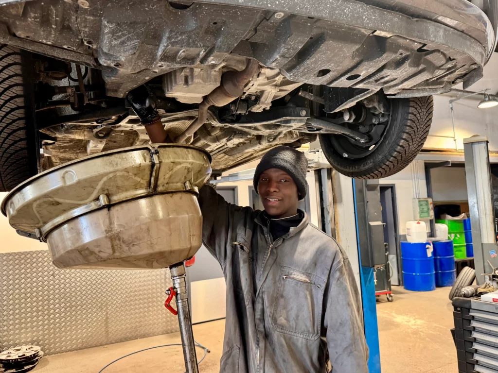 Portrait d'un apprenti mécanicien effectuant une vidange dans notre garage Melun Renault Dacia Berard Automobile.